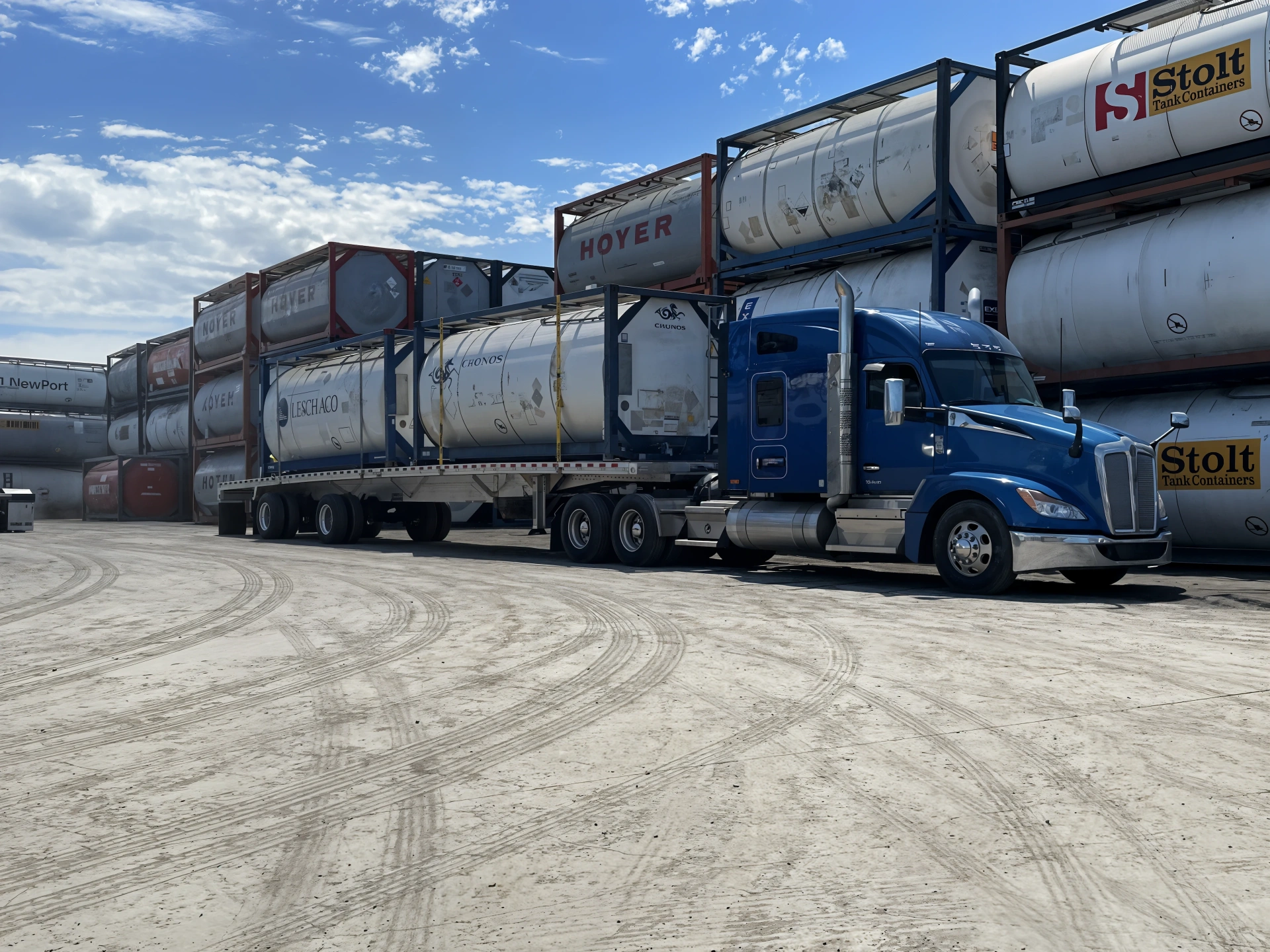 ISO tank containers stacked at a depot with a tractor under load